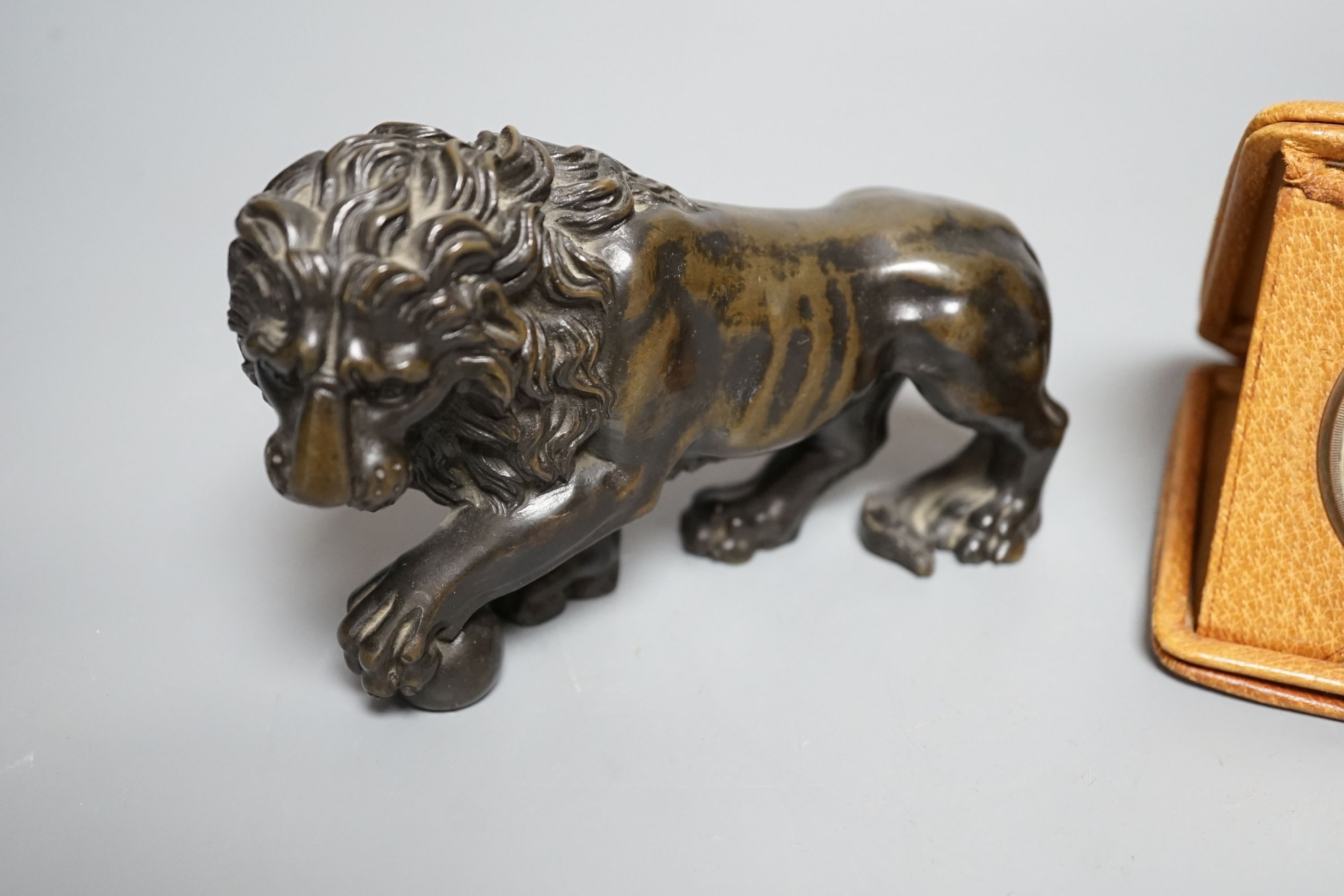 A bronze lion and Tiffany travelling watch, in tan leather case, lion 16.5 cms wide.